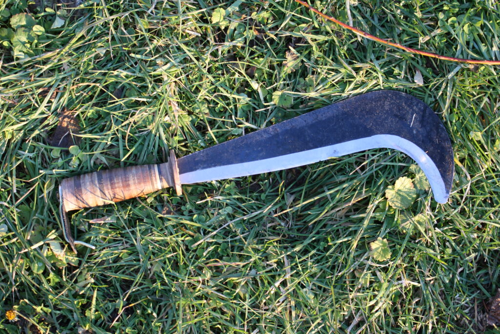 a Swiss billhook sitting on the grass
